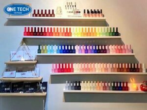 Kệ trưng bày nail nhiều tầng giúp sắp xếp lọ sơn gọn gàng trong tiệm nail chuyên nghiệp.
