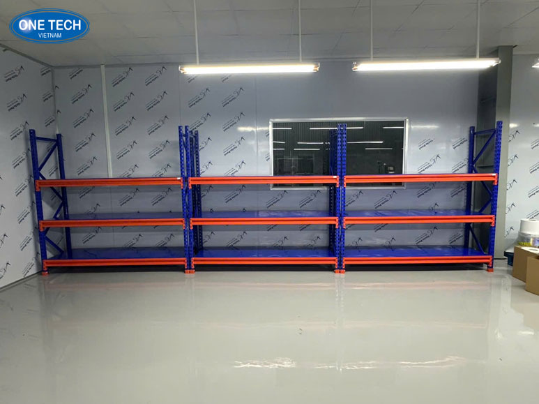 Lý do nên sử dụng kệ trung tải trong kho hàng và cửa tiệm Kệ trung tải màu xanh cam trưng bày hàng hóa gọn gàng trong kho chứa hiện đại