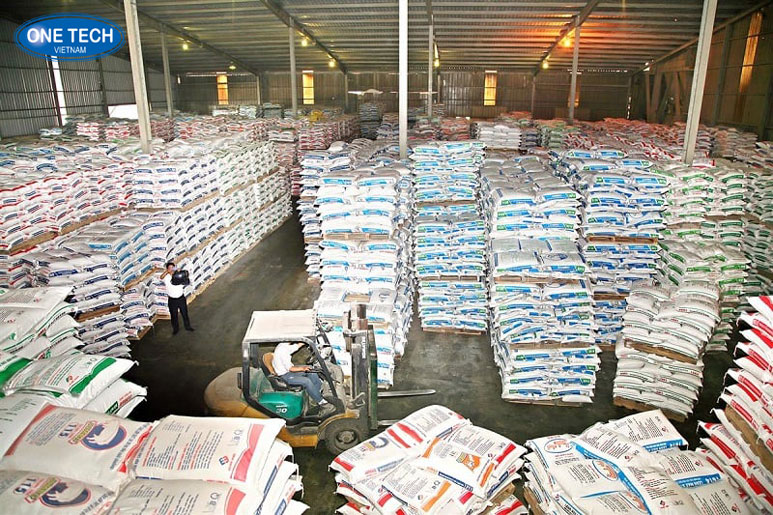 Mở đại lý phân phối thức ăn chăn nuôi và thuốc thú y Người chủ đang sắp xếp các bao thức ăn chăn nuôi và sản phẩm thuốc thú y trong cửa hàng đại lý