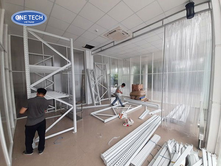 Chuẩn bị lắp kệ trung tải: Dụng cụ và mặt bằng cần thiết Công nhân chuẩn bị dụng cụ và dọn dẹp mặt bằng để lắp kệ trung tải trong kho hàng