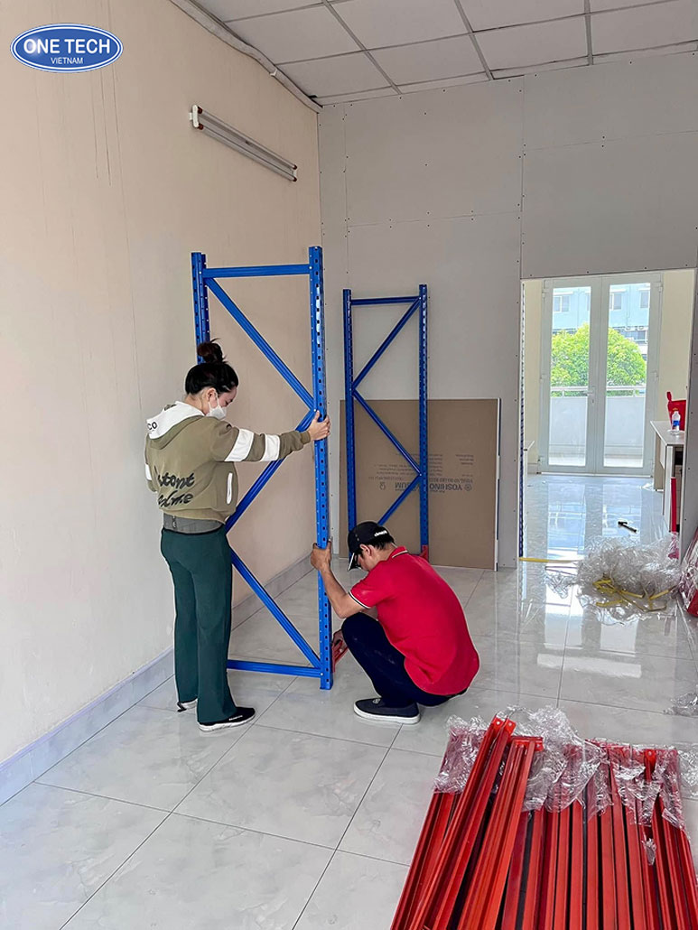 Lắp khung chân trụ kệ trung tải tại kho hàng Công nhân đang lắp khung chân trụ cho kệ trung tải trong kho
