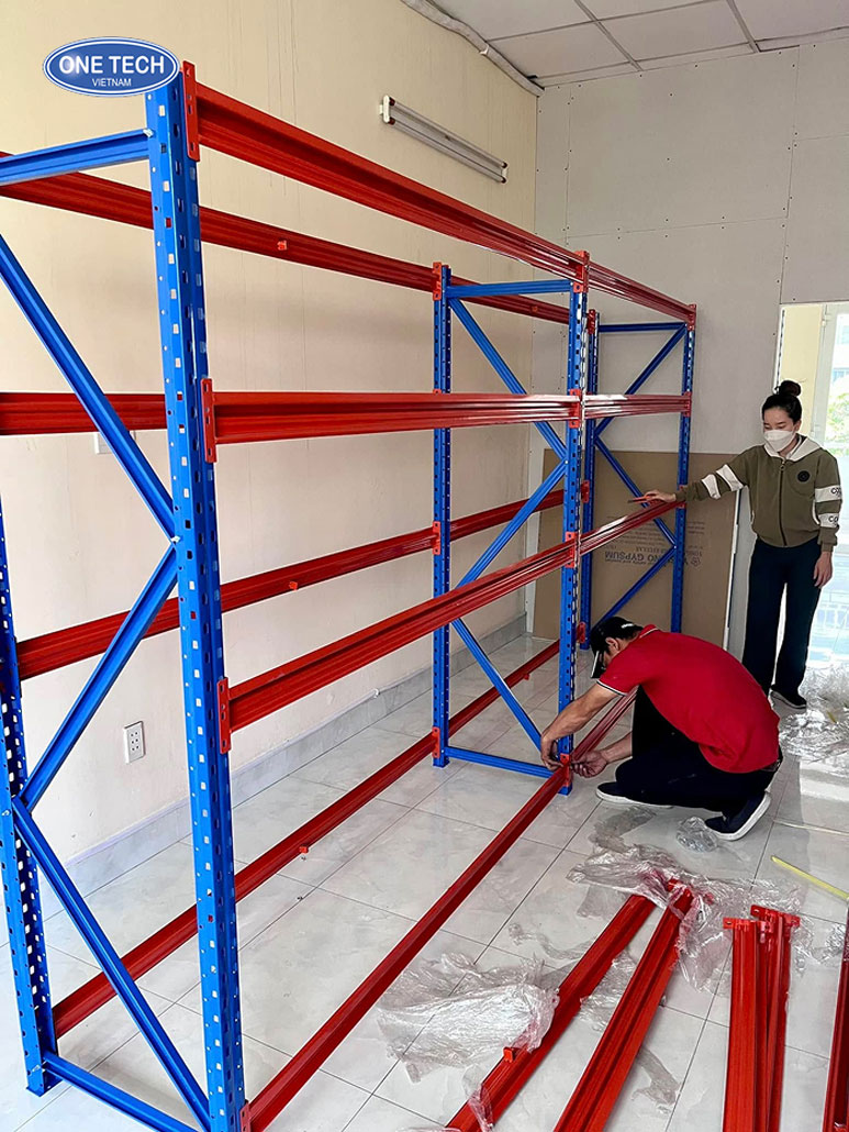 Gắn beam vào chân trụ kệ trung tải – Bước 2 lắp đặt Người thao tác lắp tay đỡ (beam) vào chân trụ trong quá trình lắp kệ trung tải