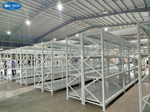 Kệ trung tải màu trắng được lắp đặt trong kho hàng để lưu trữ hàng hóa gọn gàng và tối ưu không gian